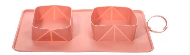 Comedero portátil para perros de silicona con dos recipientes para agua y alimento. Ideal para viajes, paseos y aventuras con tu mascota.
